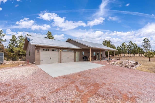 view of front of property with metal roof, driveway, and an attached garage