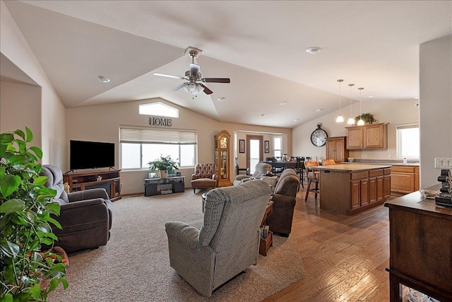 living area with lofted ceiling, wood finished floors, and ceiling fan