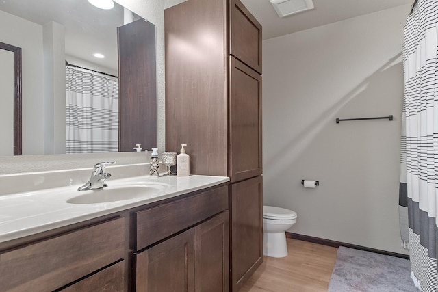 bathroom with visible vents, baseboards, toilet, wood finished floors, and vanity