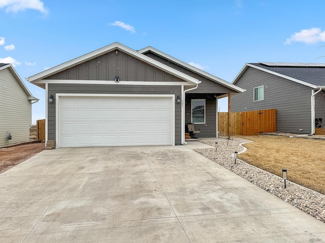 ranch-style house with driveway, an attached garage, and board and batten siding