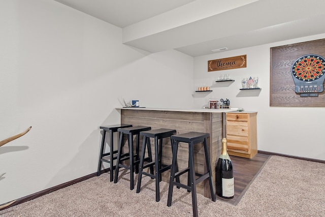 bar with a bar, visible vents, baseboards, and carpet flooring