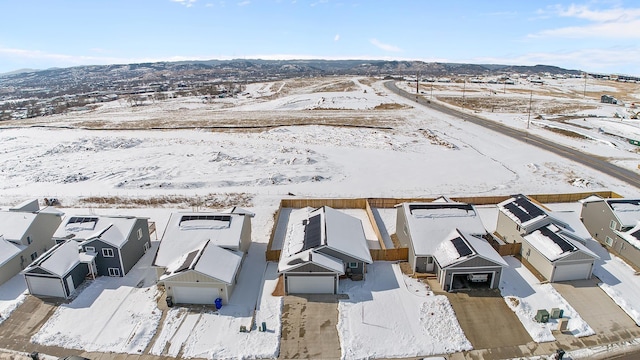 snowy aerial view featuring a residential view and a mountain view