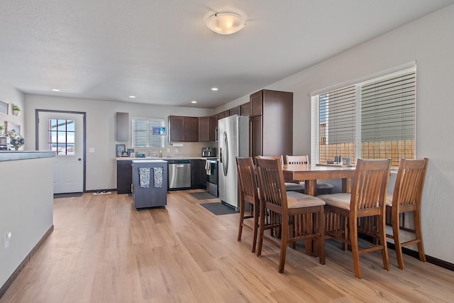 dining room featuring baseboards, a textured ceiling, recessed lighting, and light wood-style floors