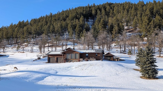 snowy aerial view with a wooded view