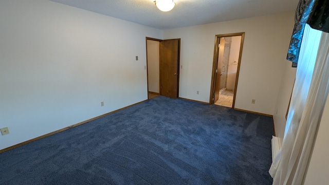 unfurnished bedroom featuring carpet, connected bathroom, baseboards, and a textured ceiling