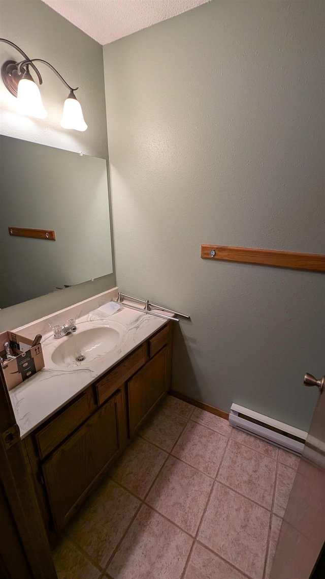 bathroom with vanity, baseboard heating, a textured ceiling, and tile patterned floors