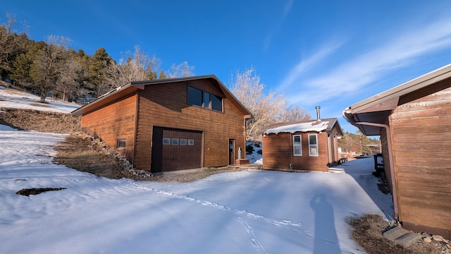 view of snowy exterior with a garage