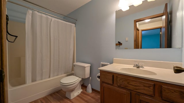 full bathroom featuring wood finished floors, shower / bath combo with shower curtain, vanity, and toilet