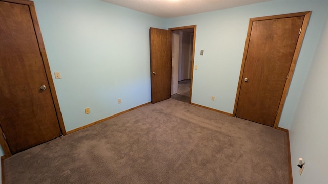 unfurnished bedroom featuring light colored carpet and baseboards