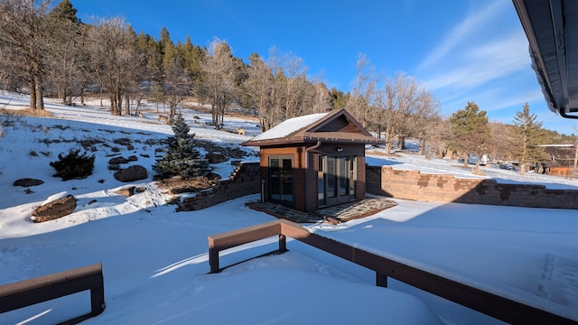 yard layered in snow with an outdoor structure