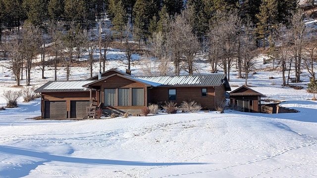 chalet / cabin with a garage and metal roof