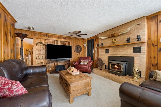 carpeted living area featuring wood walls, a textured ceiling, and ceiling fan