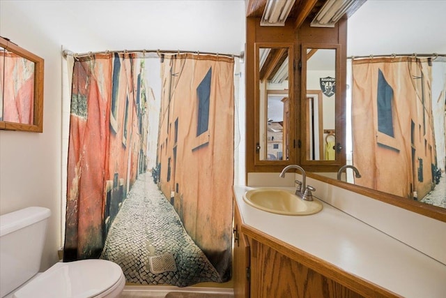 bathroom featuring a shower with shower curtain, vanity, and toilet