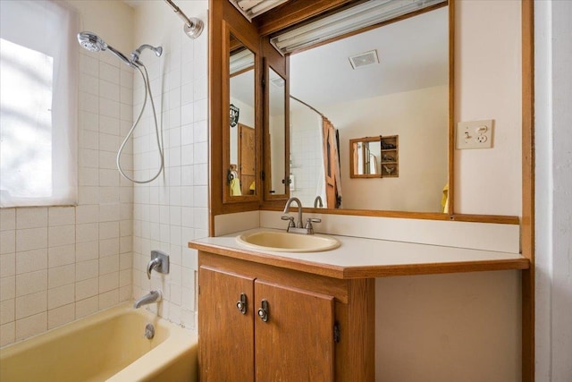 bathroom featuring vanity, visible vents, and shower / bathing tub combination