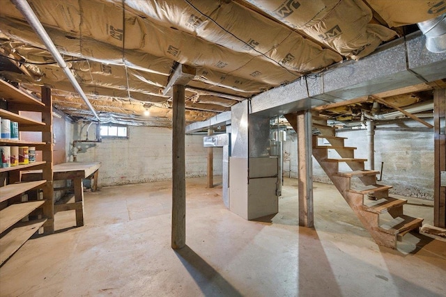 basement featuring stairway and heating unit