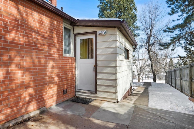 view of home's exterior with brick siding and fence