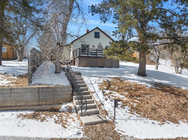 snowy yard featuring a wooden deck and stairs