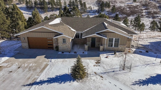 view of front of home featuring stone siding, board and batten siding, and concrete driveway