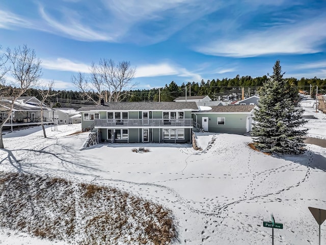 snow covered rear of property with stairs