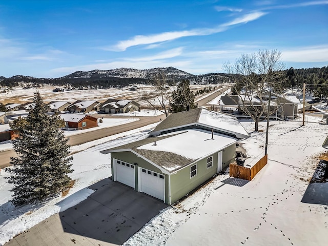 snowy aerial view with a mountain view and a residential view