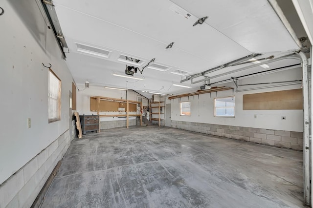 garage featuring concrete block wall and a garage door opener