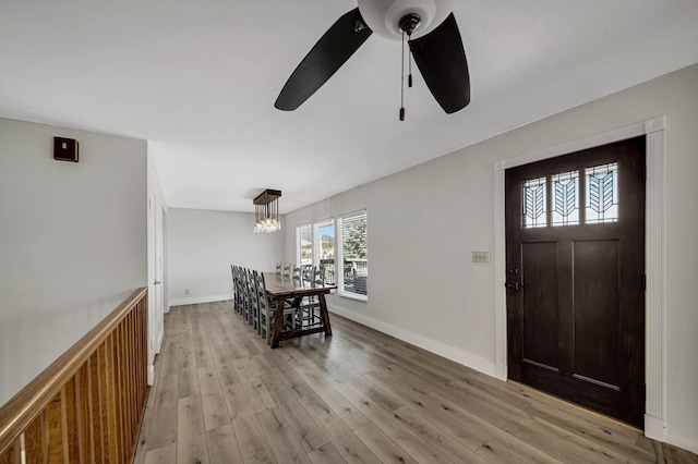 foyer with light wood-style floors, baseboards, and ceiling fan