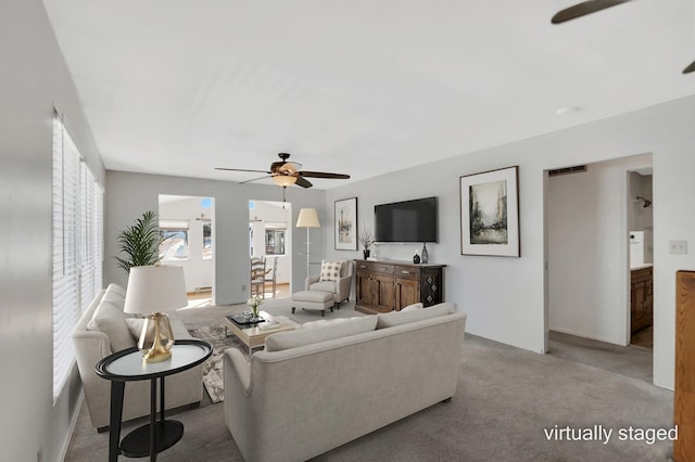 living room featuring carpet and a ceiling fan