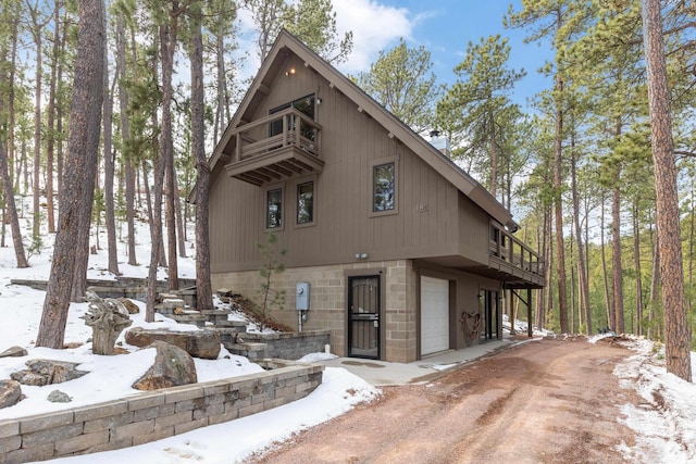 chalet / cabin featuring an attached garage and dirt driveway