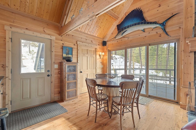 dining area with wooden walls, wood ceiling, and light wood-style flooring