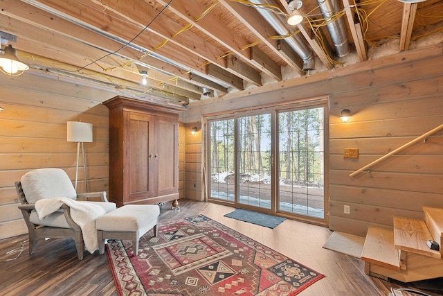 sitting room featuring wooden walls and wood finished floors