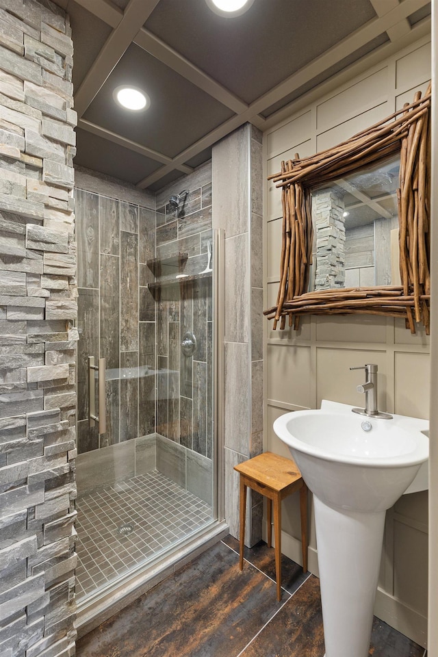 bathroom with a decorative wall and a stall shower