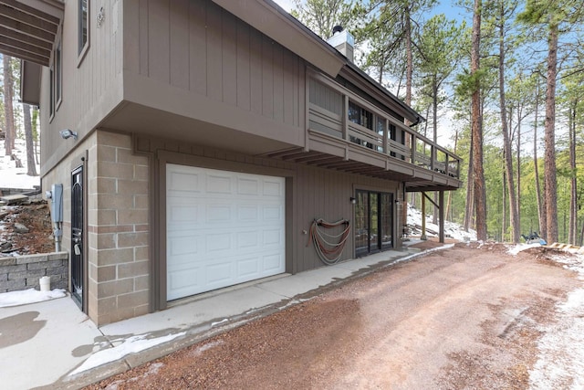 view of home's exterior featuring a chimney and a garage