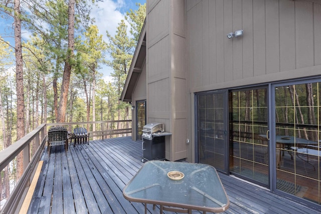 wooden terrace featuring a grill and outdoor dining area