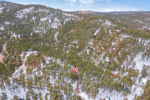 drone / aerial view with a wooded view and a mountain view