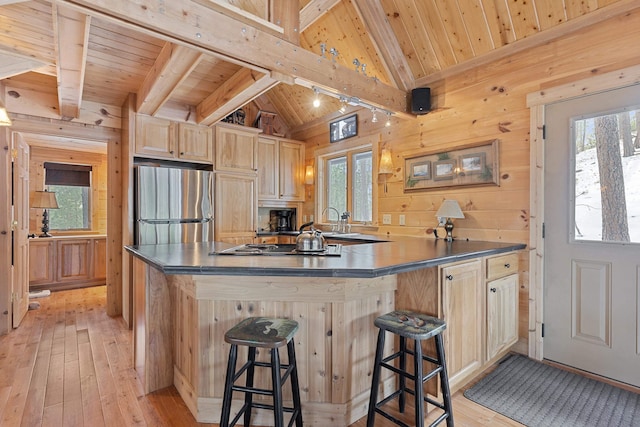 kitchen with light brown cabinets, freestanding refrigerator, wood walls, light wood finished floors, and wood ceiling