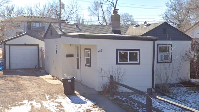 219 St Patrick St, Rapid City, SD 57701 - view of front of property featuring an outdoor structure, concrete driveway, a chimney, and roof with shingles