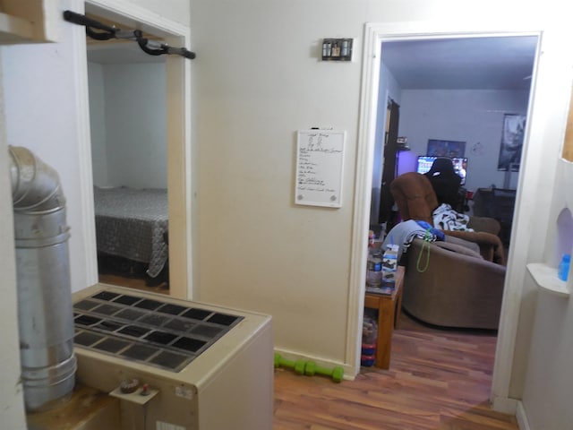 hall with baseboards and wood finished floors