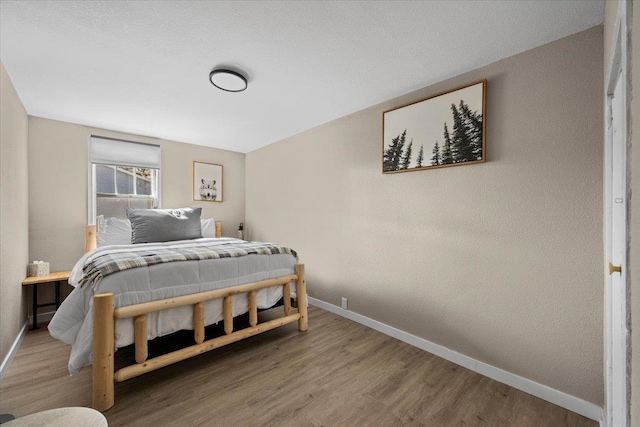 bedroom with wood finished floors and baseboards