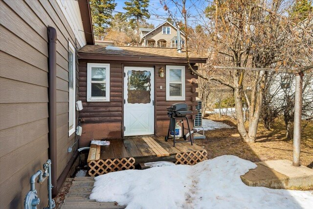 property entrance with a shingled roof