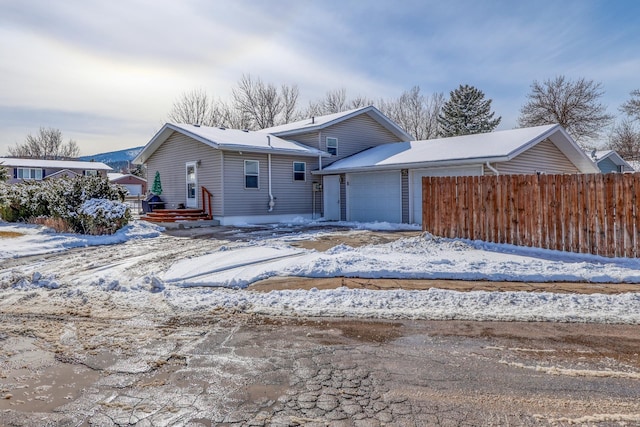 view of front of property featuring fence and a garage