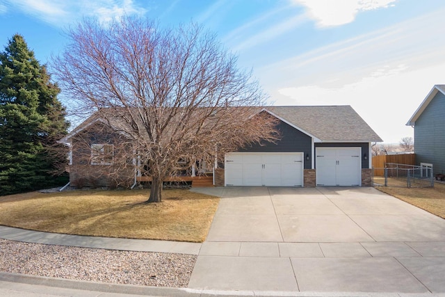 ranch-style house featuring brick siding, fence, a front yard, a garage, and driveway