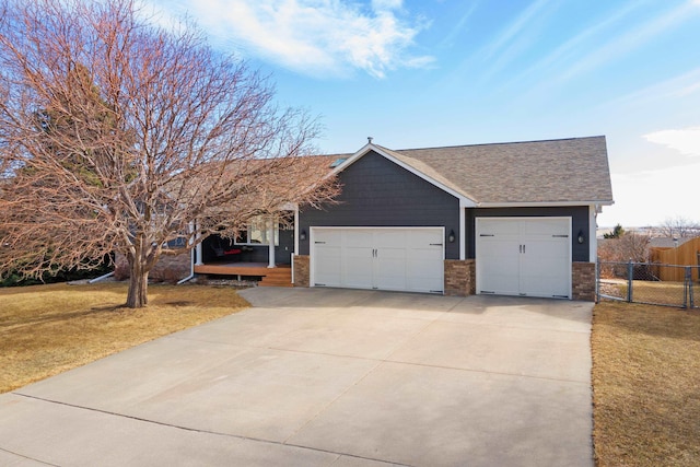 single story home featuring fence, a front yard, roof with shingles, a garage, and driveway