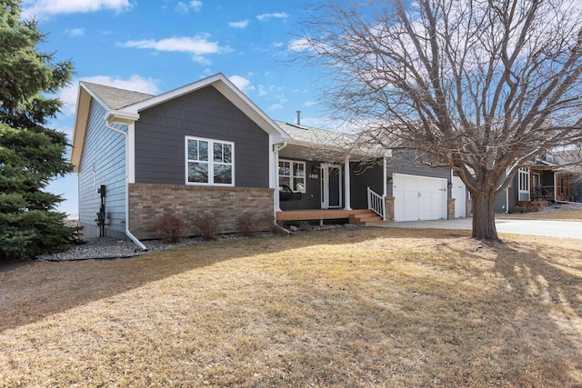 single story home with brick siding, a front yard, covered porch, a garage, and driveway