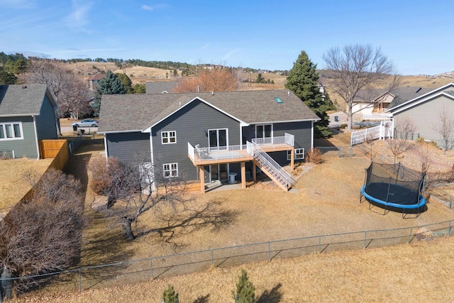 3418 Gray Fox Ct, Rapid City, SD 57701 - back of property featuring a trampoline, fence, stairway, a wooden deck, and roof with shingles