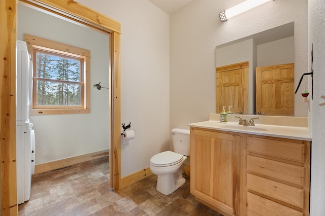 bathroom featuring visible vents, stone finish flooring, baseboards, toilet, and vanity