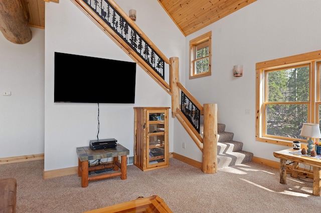 living area featuring carpet flooring, wooden ceiling, stairs, and baseboards