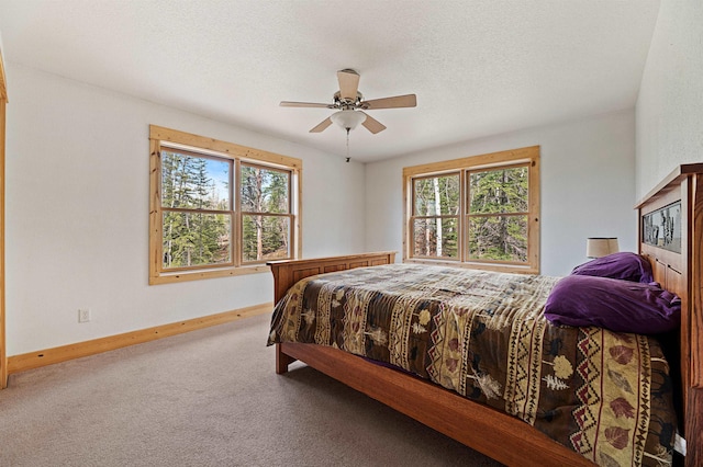 carpeted bedroom with ceiling fan, a textured ceiling, and baseboards