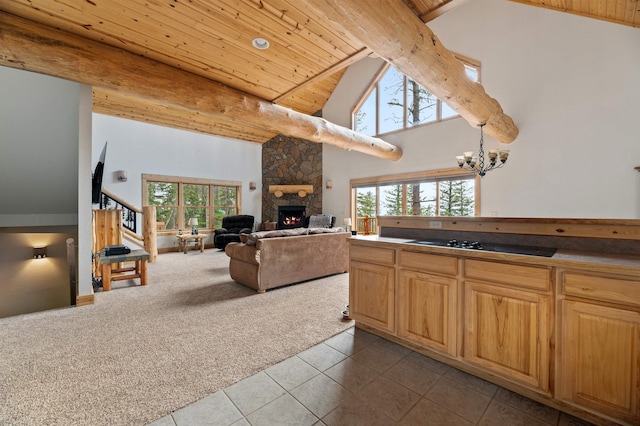 kitchen featuring beam ceiling, a fireplace, dark colored carpet, and a wealth of natural light