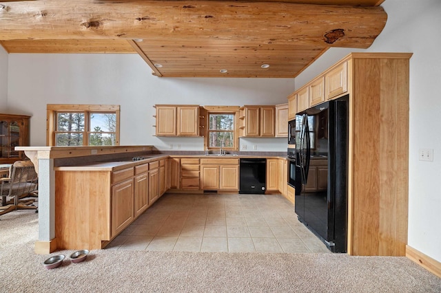 kitchen featuring black appliances, vaulted ceiling with beams, light brown cabinets, and a peninsula