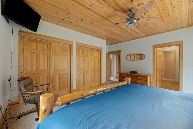 bedroom with connected bathroom, multiple closets, wood ceiling, and a ceiling fan